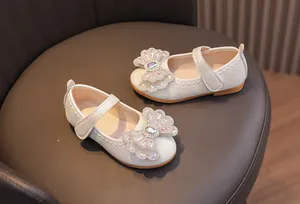 Macro detail of iridescent white Mary Janes with rhinestone bow and quilted pattern