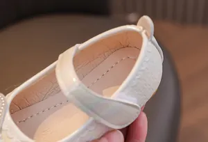 Detail of girls princess shoes showing velcro closure and textured pearlescent finish
