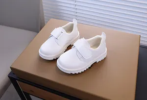 Détail de chaussures en cuir blanc pour garçons avec doublure en peluche et velcro
