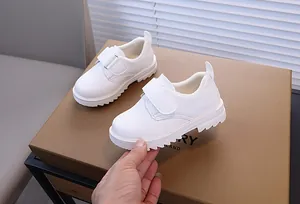 Détail de chaussures en cuir blanc pour enfants avec velcro et doublure polaire