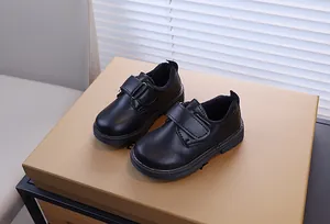 Gros plan de chaussures en cuir noir pour garçons avec fermeture à velcro mate