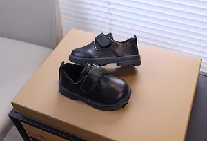 Détail de chaussures en cuir noir pour garçon avec doublure chaude et fermeture velcro