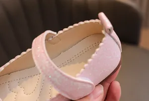 Détail de chaussures de princesse roses pailletées avec semelle à cœurs et velcro