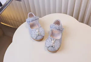 Détail de chaussures de princesse pailletées avec brides en dentelle et nœud lapin