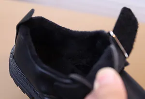 Détail de chaussures en cuir noir pour garçon montrant la doublure polaire chaude