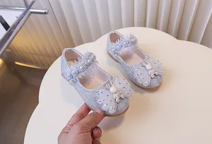 Détail de chaussures Mary Jane pailletées argent avec nœud en résille et lapin décor