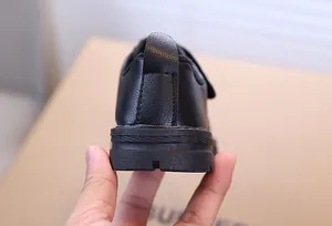 Détail d'une chaussure d'école noire pour garçon avec semelle en caoutchouc et languette arrière