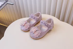 Détail de chaussures de princesse pailletées avec papillon en strass et perles dentelle