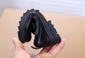 Détail de chaussures flexibles en cuir noir pour garçon avec semelle en caoutchouc souple