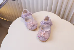 Détail de chaussures princesse roses avec paillettes, roses en dentelle et nœuds lapin