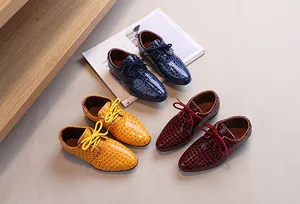 Detail of boys' patent leather dress shoes featuring alligator texture in blue yellow and red