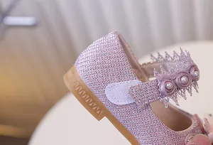 Gros plan sur les chaussures roses à paillettes avec dentelle et semelle en caoutchouc