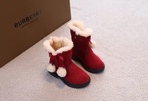 Dettaglio stivali da neve rossi per bambine con fodera in peluche e pompon decorativi