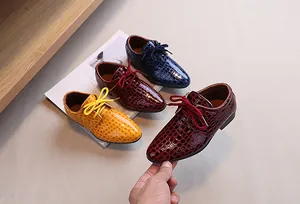 Detailed macro view of glossy embossed crocodile pattern leather on stylish boys dress shoes