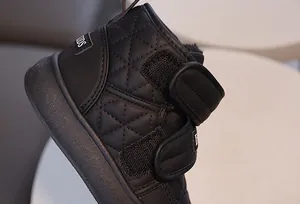 Détail de bottes de neige noires pour enfants en cuir matelassé avec bandes velcro