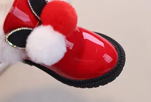 Dettaglio stivaletti bimba in vernice rossa con pompon di peluche e strass scintillanti