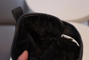 Gros plan sur les bottes de neige d'hiver avec doublure polaire noire et bordure en cuir