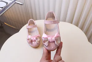 Detailweergave van de roze lakschoen Mary Jane met een glitterstrik en klittenbandsluiting