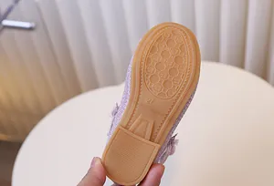 Gros plan de la chaussure princesse violette à paillettes pour fille avec fleur et semelle 27