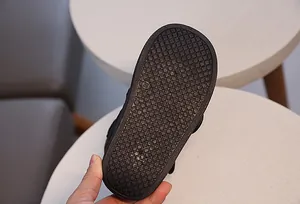 Gros plan de la semelle antidérapante noire pour bottes d'enfants avec marquage de taille 24