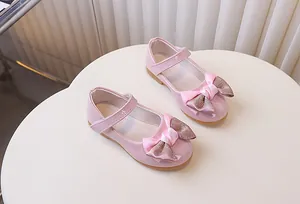 Detailopname van roze lakschoenen Mary Jane met glitterstrik en klittenbandsluiting