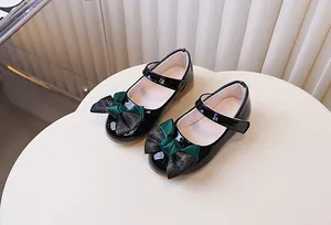 Detail van zwarte lakschoenen Mary Jane met glitterstrik en klittenband voor meisjes