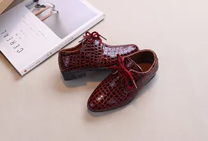 Detailed shot of burgundy crocodile pattern leather dress shoes for boys with laces