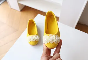 Detail of yellow suede girls princess flats with soft floral pearls and non-slip sole