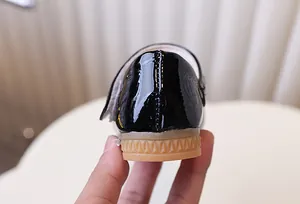 Detailopname van zwarte lakschoenen voor meisjes met glanzende afwerking en antislipzool