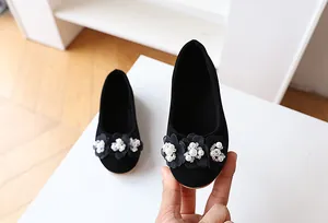 Detailed view of kids suede ballerina flats featuring 3D flowers and white pearl accents