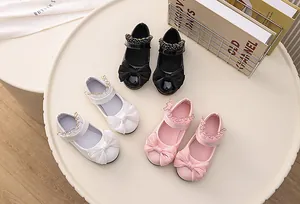 Flat lay of girl's Mary Jane shoes in pink, white and black with large bow details