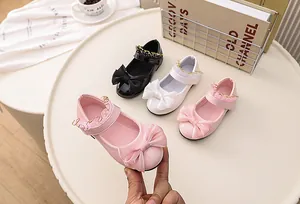 Three pairs of girls Mary Jane shoes in pink white and black with bows and gold chains
