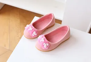 Detail of pink girls ballet flat with 3D suede flowers and white faux pearls
