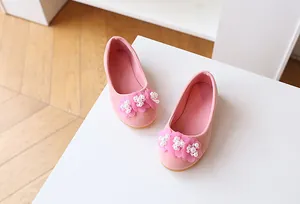 Detail view of pink suede girls princess shoes with soft floral and pearl decorations