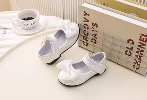 Close-up of white girls' princess shoes with satin bow and delicate lace detailing
