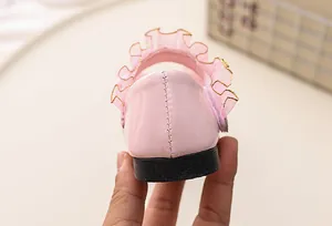 Detailed back view of pink patent leather girls' princess shoe with ruffle trim details.