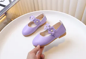 Detail of purple Mary Jane girls shoe with 3D flowers and pearl accents on white tray