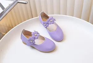 Close-up of lavender girls Mary Jane shoes with floral accents and pearl centers