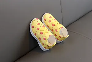 Détail de chaussures jaunes pour enfants avec motif fraise et semelles antidérapantes