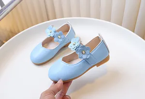 Detail of light blue girls Mary Jane shoes with floral leather petals and pearl center