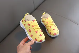 Détail de chaussures fillette à motif fraise en maille jaune avec semelle antidérapante