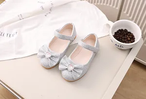 Detail von silbernen Glitzer-Babyschuhen mit Herz-Kristall-Schleife und weicher Sohle