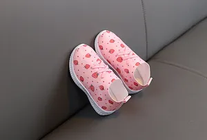 Détail de basket rose pour enfant avec motif fraise et semelle en caoutchouc blanc