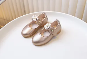 Detail of champagne gold girls' Mary Janes with floral pearls and metallic finish