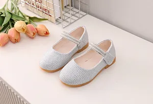 Detail of silver sequin Mary Jane shoes for girls with pearl velcro straps and rubber soles