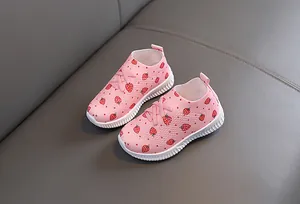 Gros plan de chaussures roses pour filles avec motifs fraises et tissu en maille respirant