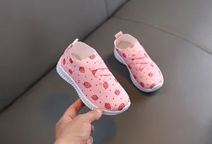 Gros plan sur les chaussures roses pour tout-petits avec motifs fraises et maille respirante