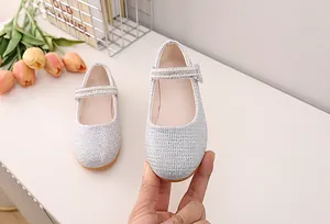 Detailed macro view of silver glitter Mary Jane shoes with elegant pearl buckle strap