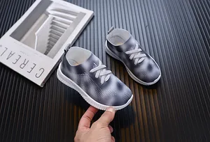 Détail d'une basket respirante en maille grise pour fille sur fond rayé minimaliste