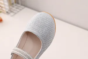 Close-up of silver glitter girls Mary Jane shoes with pearl and rhinestone details